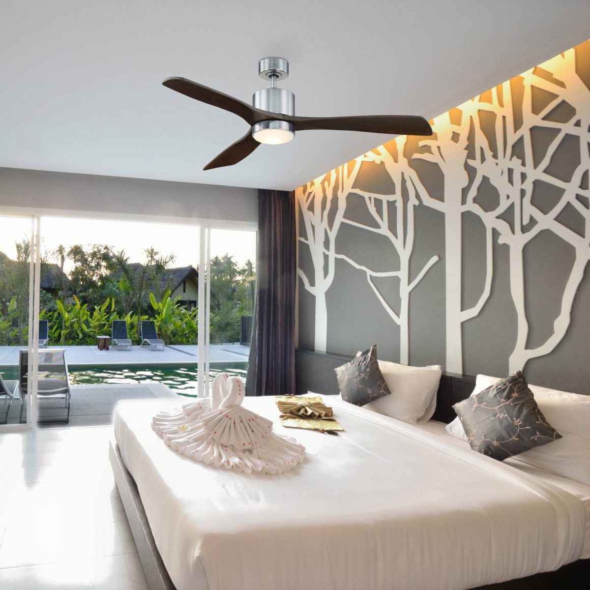 A contemporary bedroom with mid-century modern ceiling fan and large windows facing the swimming pool