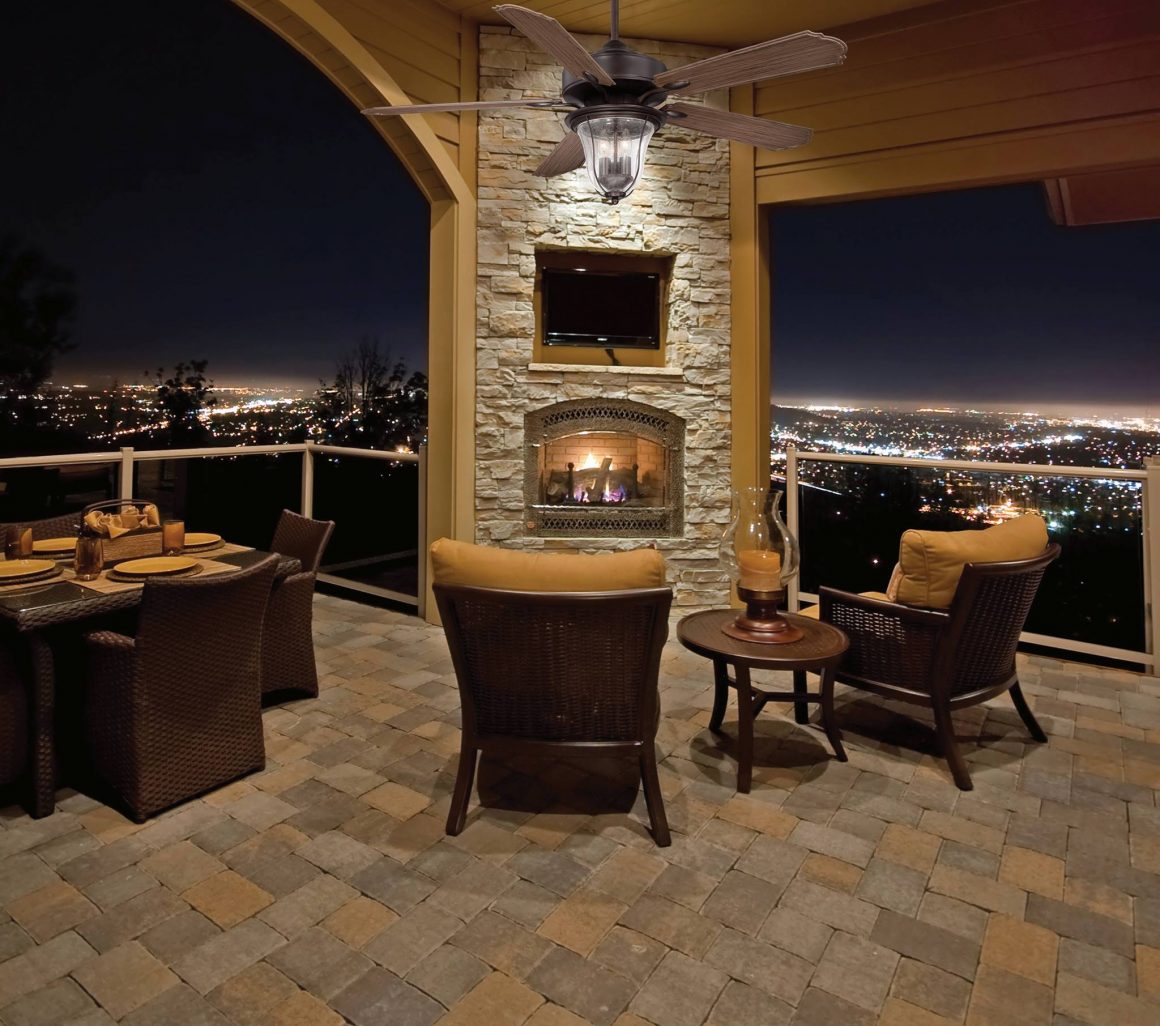 A beautiful backdrop of  a backyard patio with outdoor furniture and city lights in the background